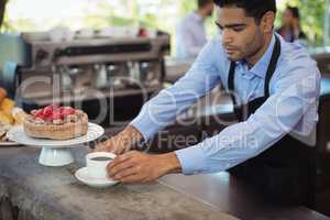 Waiter serving coffee at counter