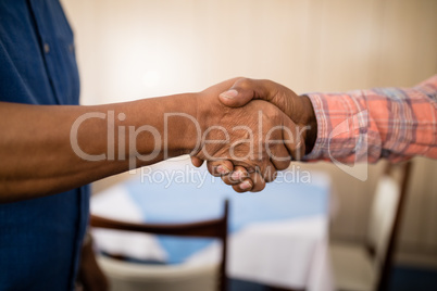 Cropped image of senior friends doing handshake