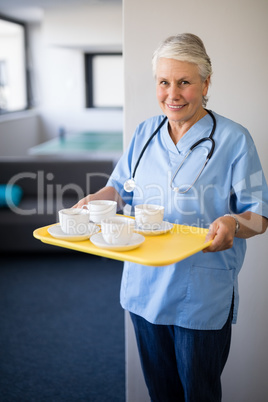 Portrait of senior healthcare worker holding coffee cups