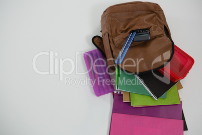 Schoolbag with various supplies on white background