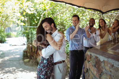 Friends embracing each other at counter Friends embracing each other at counter