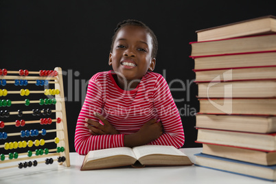 Cute girl with abacus and stack of books