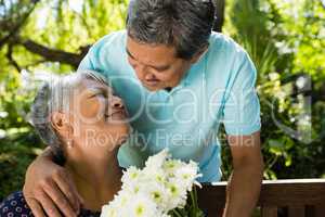 Senior man giving flowers to woman