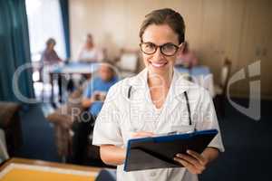 Portrait of smiling female doctor standing with file