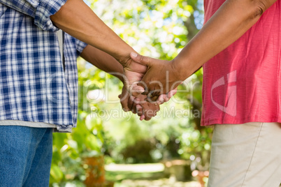 Mid-section of senior couple holding hands