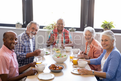 Portrait of senior people having breakfast at table