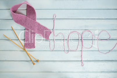 Overhead view of pink Breast Cancer Awareness ribbon by hope text and crochet needles