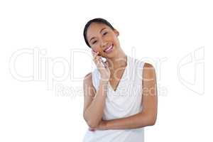 Happy businesswoman with head cocked talking on mobile phone