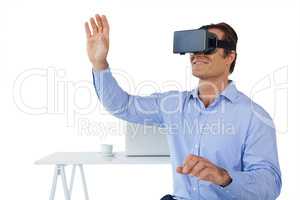 Smiling businessman with arms raised using vr glasses