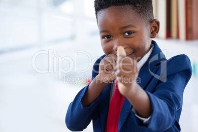 Portrait of boy imitating as businessman playing with rubber band
