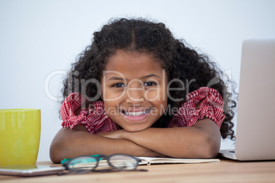 Portrait of smiling businesswoman leaning on desk