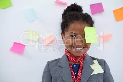 Portrait of smiling businesswoman with sticky notes stuck on head