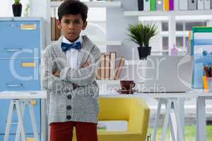 Portrait of boy pretending as businessman standing with arms crossed