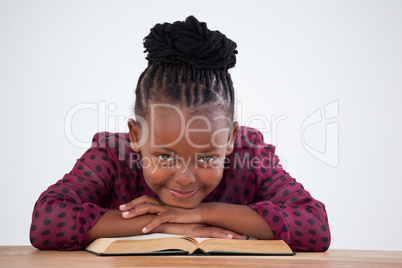 Portrait of smiling businesswoman with book leaning on desk