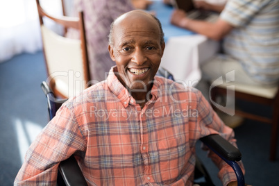 Portrait of smiling disabled senior man sitting on wheelchair
