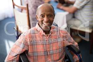 Portrait of smiling disabled senior man sitting on wheelchair