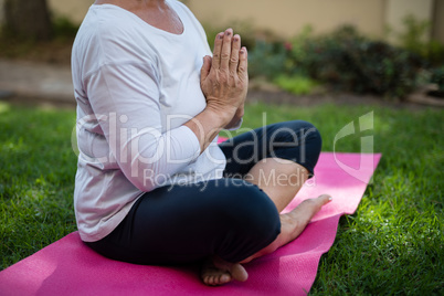 Low section of senior woman meditating in prayer position