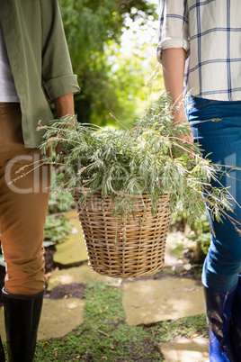 Mid-section of couple walking with flower basket