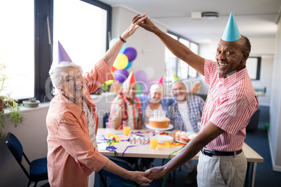 Portrait of smiling senior couple making frame against friends