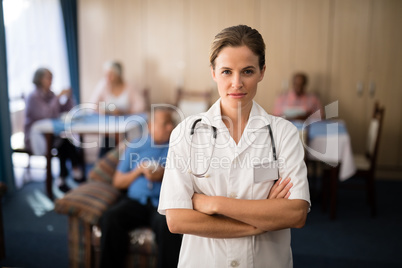 Portrait of confident female doctor standing with arms crossed