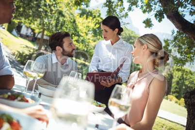 Waitress discussing the menu with customer in the restaurant