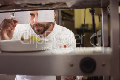 Chef reading his order on sticky note in kitchen counter