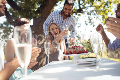 Group of friends celebrating womans birthday at outdoor restaurant