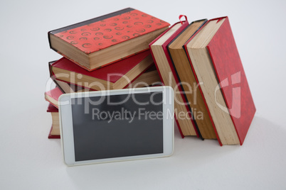Books and digital tablet arranged on white background