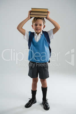 Schoolboy holding her book on her head