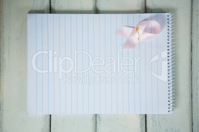 Overhead view of pink Breast Cancer Awareness ribbon and spiral notepad