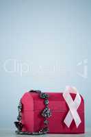 Close-up of pink Breast Cancer Awareness ribbon and jewelry on red box