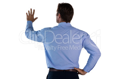 Rear view of businessman with hand on hip using invisible interface