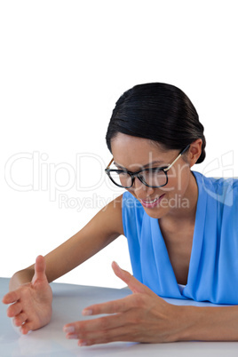 Happy businesswoman gesturing while sitting at table