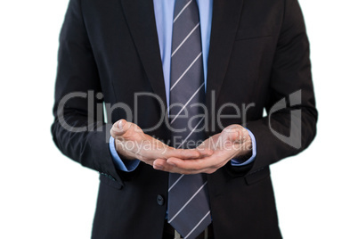 Mid section of businessman wearing suit while standing with hands cupped