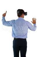 Rear view of businessman wearing VR glasses pointing