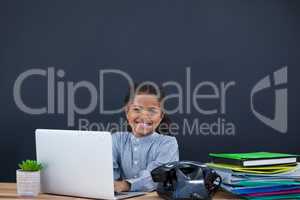 Portrait of smiling businesswoman using laptop against black background