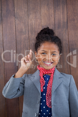 Portrait of businesswoman pointing upwards