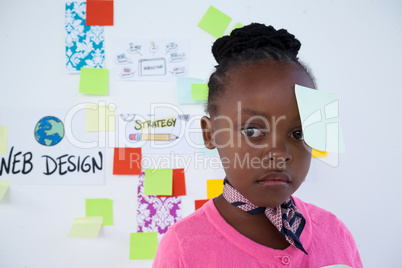 Contemplated businesswoman with sticking notes in office