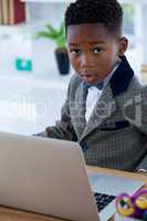 Portrait of surprised businessman using laptop