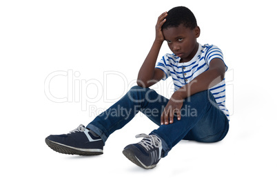 Sad boy sitting with hand on head