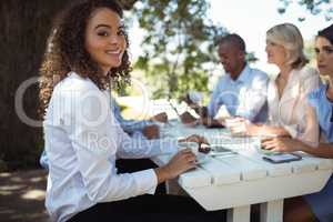 Woman sitting with friends in outdoor restaurant