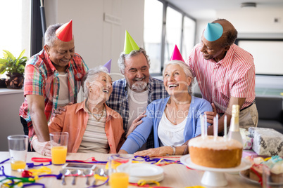 Cheerful friends looking at excited senior woman