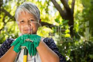 Senior woman standing in garden on a sunny day