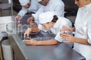 Chefs finishing dessert in glass at restaurant