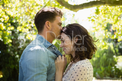Man kissing woman on forehead