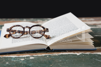 Spectacles on open book