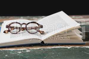 Spectacles on open book