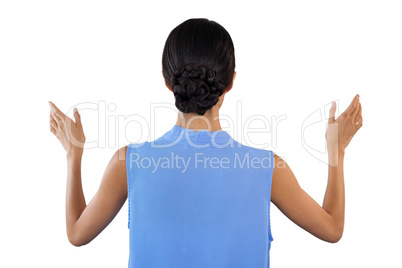 Rear view of businesswoman gesturing while using invisible interface