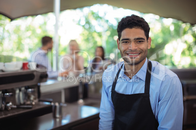 Portrait of smiling waiter at counter
