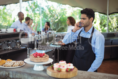 Waiter talking on mobile phone